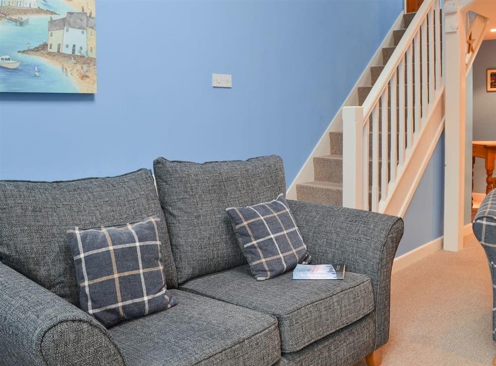 Charming living room with staircase to first floor at Wheelwright Cottage in Beaworthy, Devon
