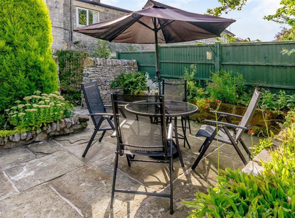 Enclosed patio area with outdoor furniture at Whibberley Cottage in Ashford-in-the-Water, near Bakewell, Derbyshire