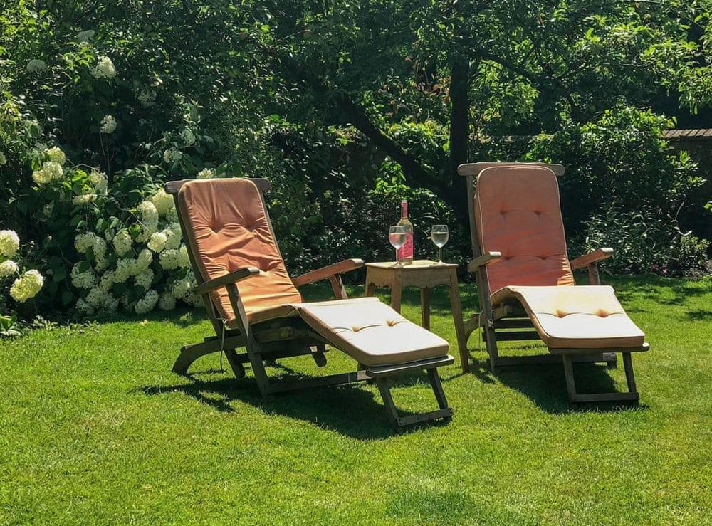 Enclosed lawned garden with garden furniture at White Horse Cottage in West Meon, near Petersfield, Hampshire