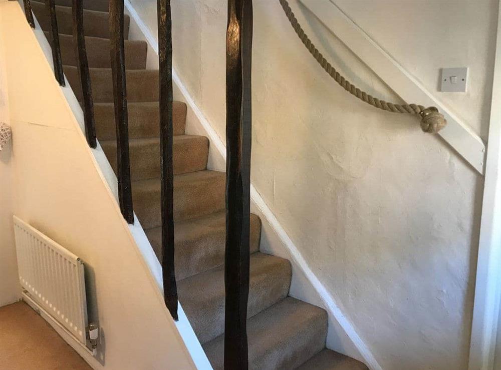 Partial, open-sided stairs to first floor with rope hand rail at White Horse Cottage in West Meon, near Petersfield, Hampshire