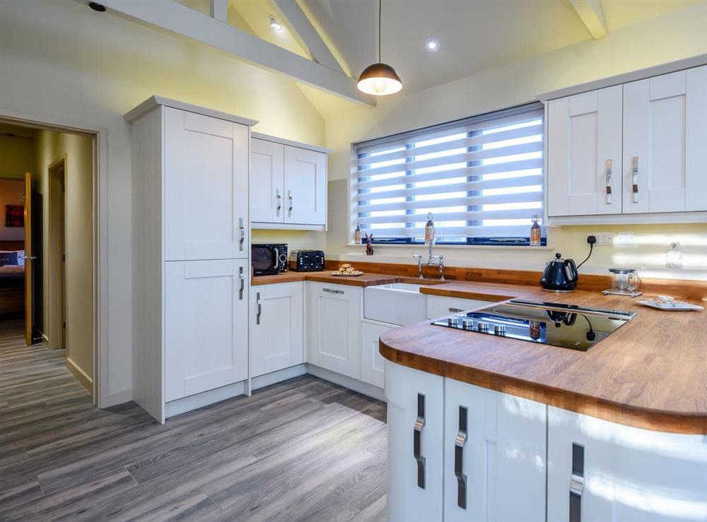 Fully equipped kitchen within the open-plan design at Laxfield Barn, 