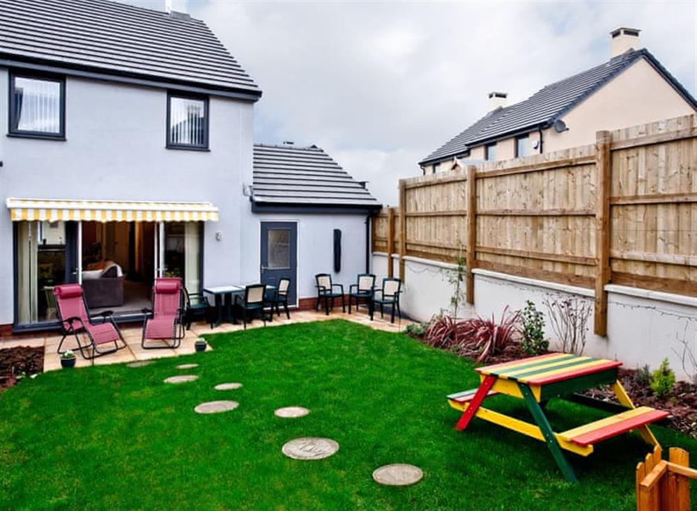 Rear of holiday home with patio and garden at White Rock in Paignton, Devon