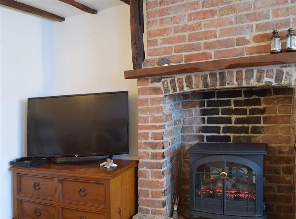Cosy living room with electric wood burner at White Stones Cottage in Caister-on-Sea, near Great Yarmouth, Norfolk