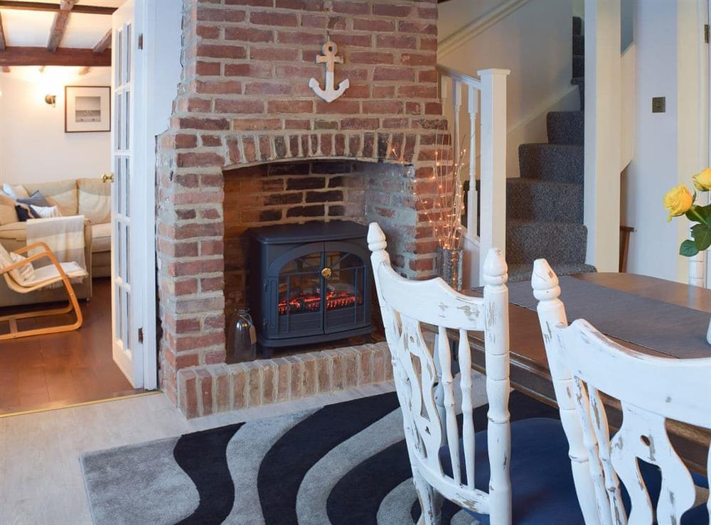 Shabby chic dining room with electric wood burner at White Stones Cottage in Caister-on-Sea, near Great Yarmouth, Norfolk