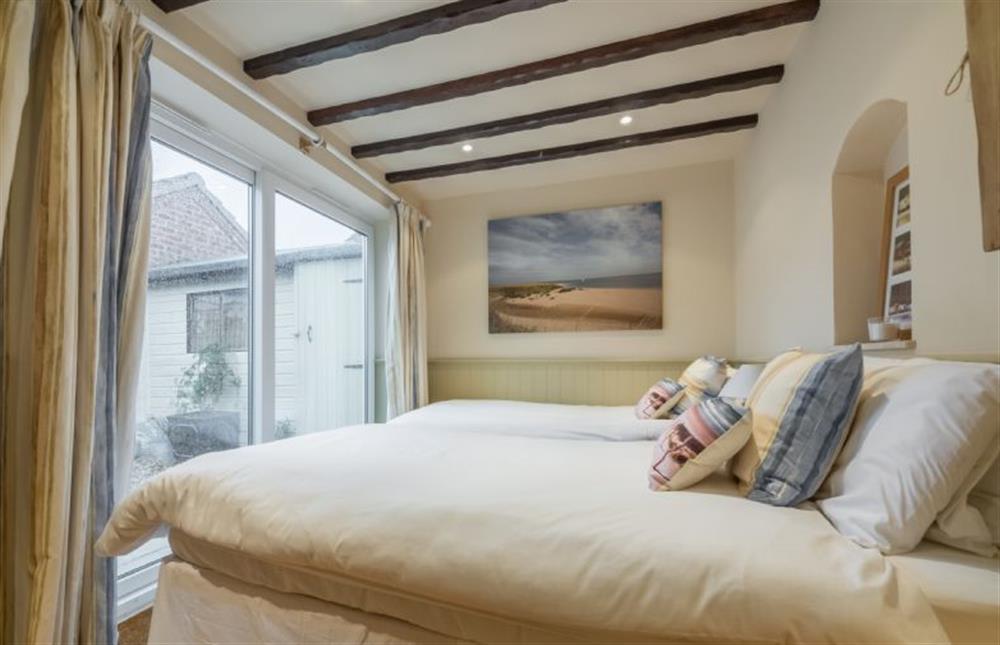 Annexe bedroom with full-size twin beds is located across the courtyard garden at Whitehaven, Brancaster near Kings Lynn