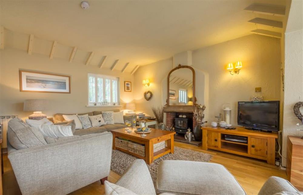 Ground floor: Sitting room with comfy sofas and electric wood burner at Whitehaven, Brancaster near Kings Lynn