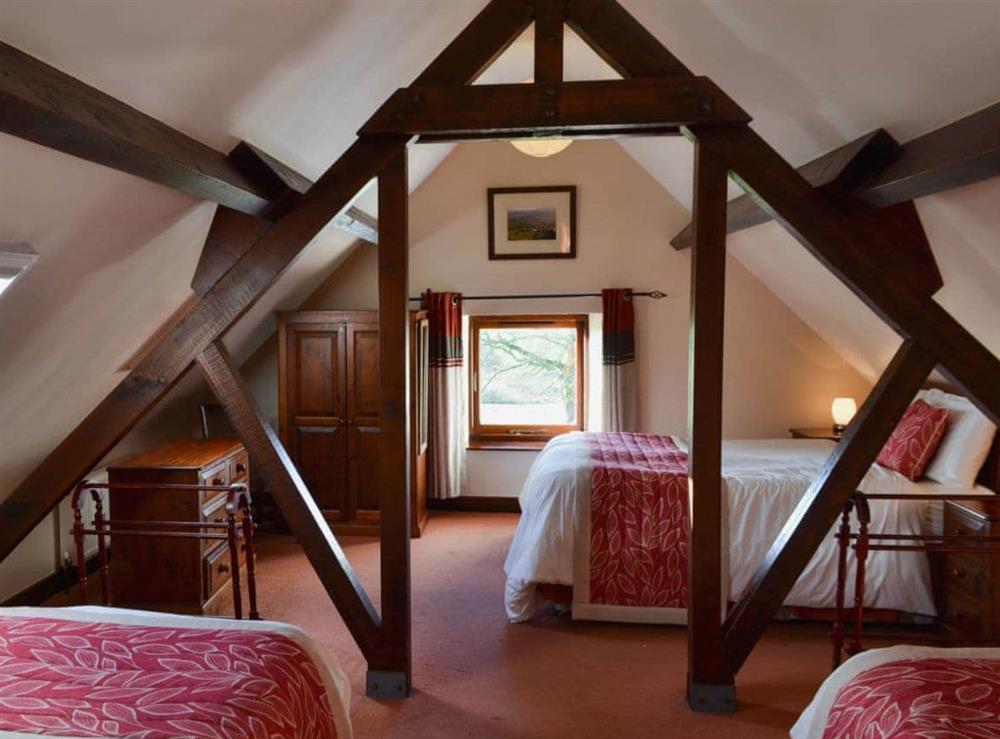 Double bedroom with two additional single beds at Whitehouse Farm Barn in Heathcote, near Hartington, Derbyshire