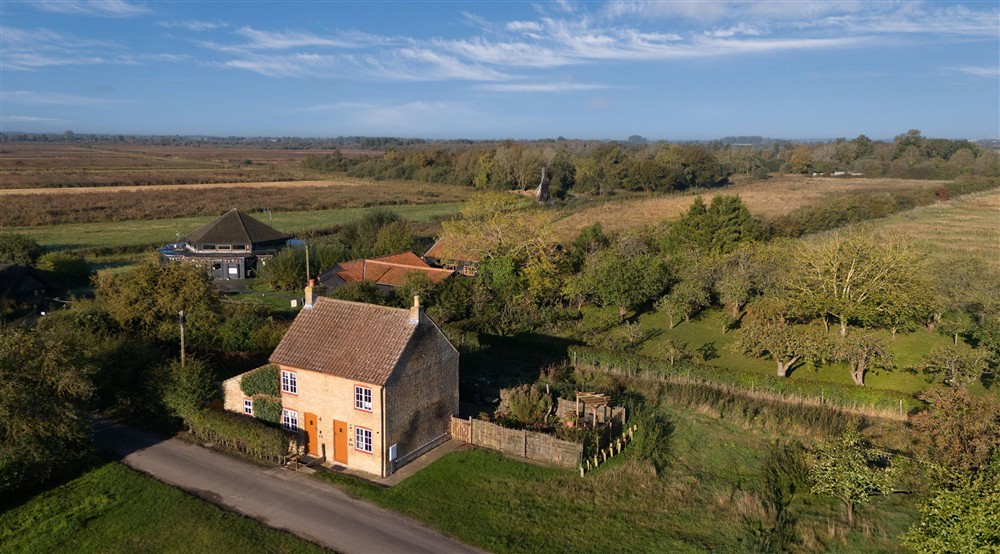 An aerial view of Cladium and Wicken Rose Cottage, with the Visitor Centre and Wicken Fen Nature Reserve in the background, Cambridgeshire at Wicken Rose Cottage in Ely, Cambridgeshire