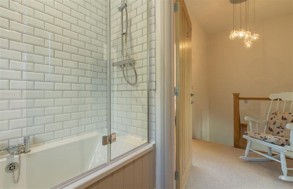 First floor: Family bathroom has bath with shower over at Wigeon Cottage, Thornham near Hunstanton