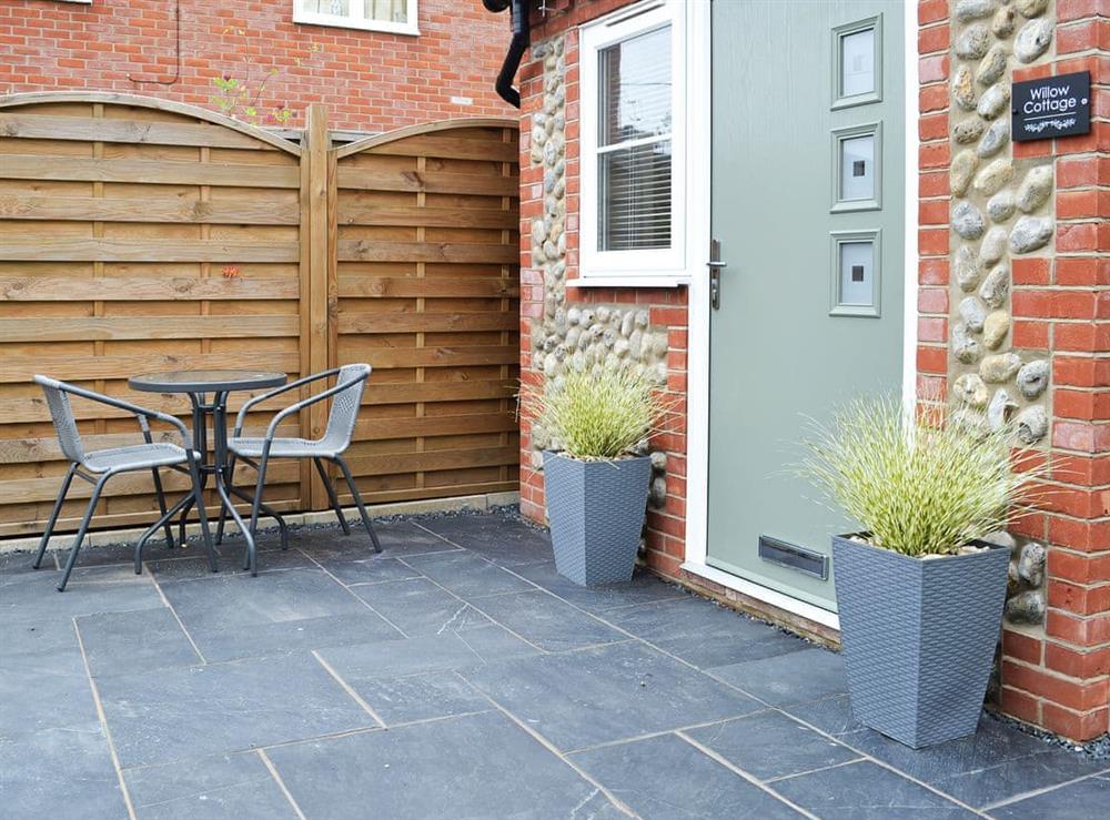 Slate-flagged area with table and chairs at Willow Cottage in Great Ryburgh, near Fakenham, Norfolk
