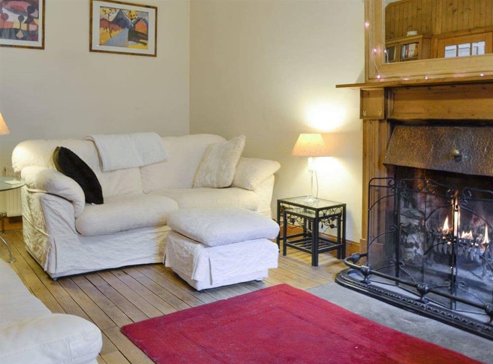 Inviting living room with open fire at Willow Cottage in Kirriemuir, Angus