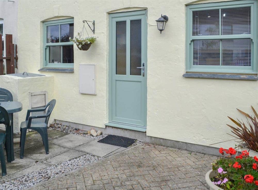 Paved patio area with table and chairs at Willow Cottage in Newquay, Cornwall