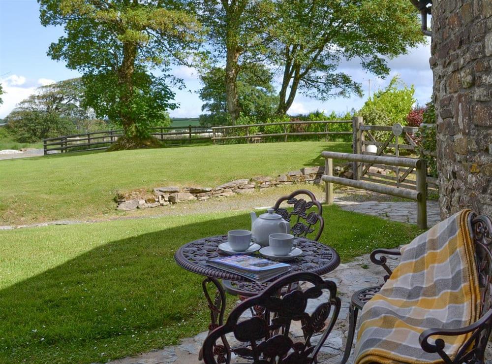 Paved patio area with outdoor furniture at Willow Cottage in Woolfardisworthy, near Bideford, Devon