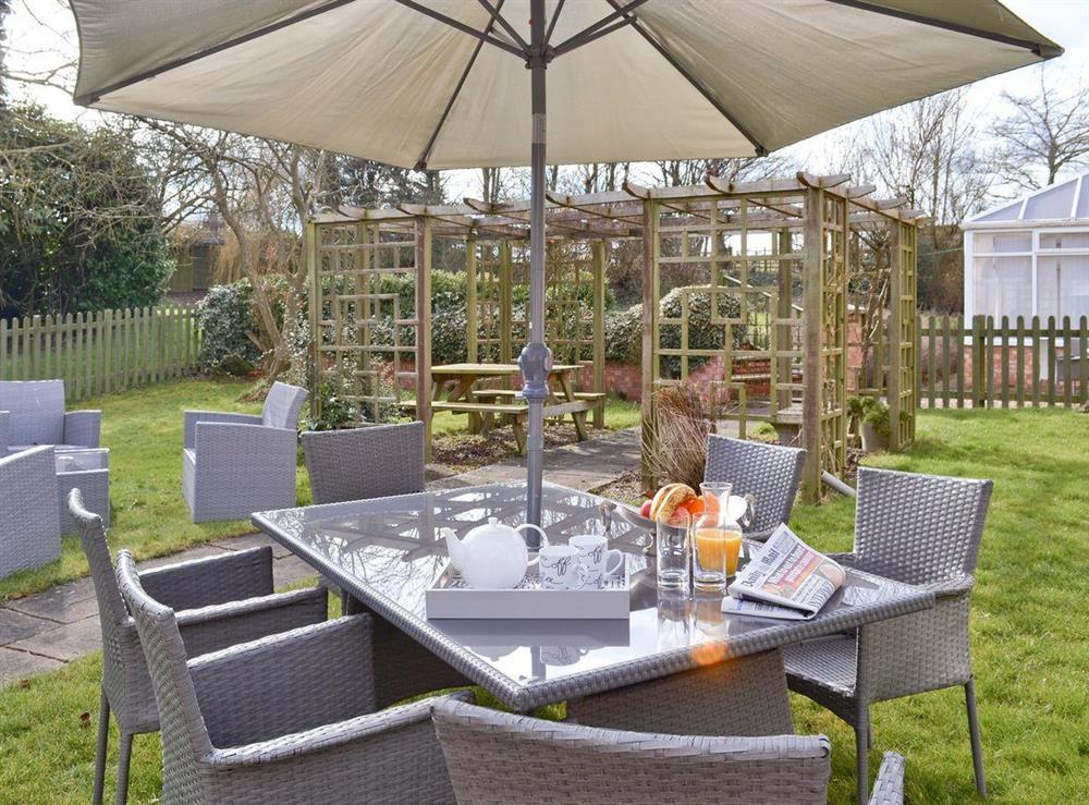 Garden accommodating both outdoor eating and seating areas at Willow Tree Cottage in Foxholes, near Driffield, North Yorkshire
