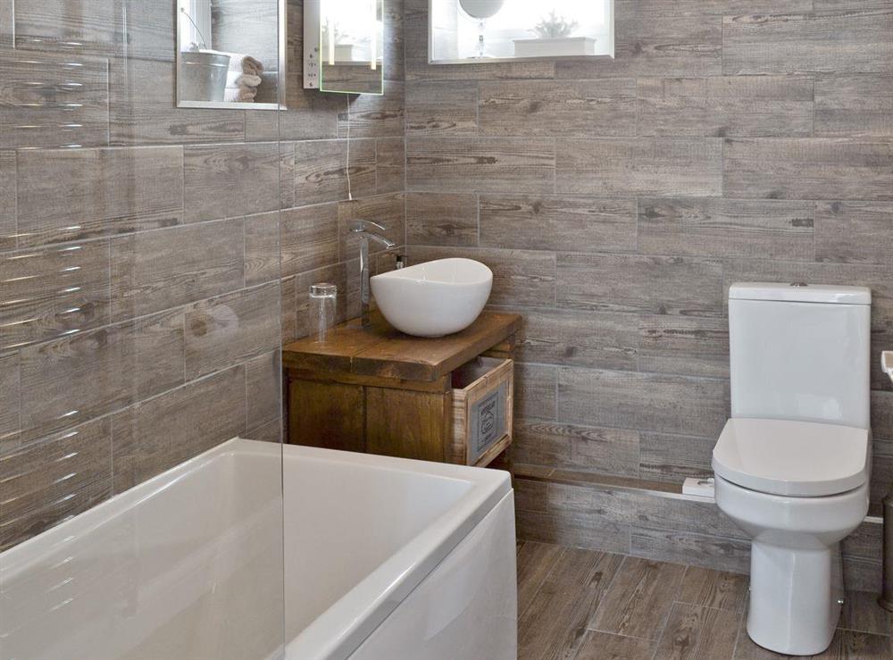 Modern family bathroom with shower over bath at Willow Tree Cottage in Foxholes, near Driffield, North Yorkshire