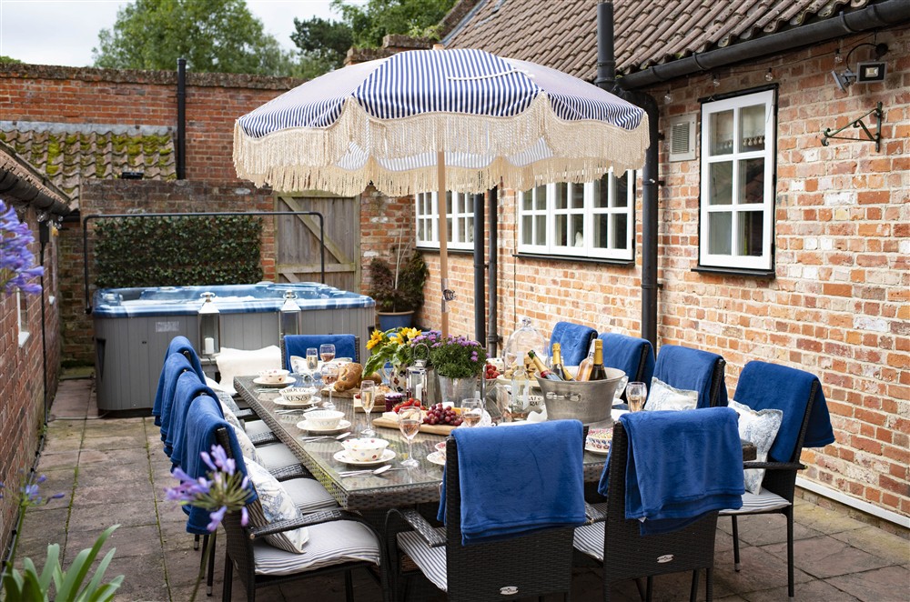 Courtyard with dining furniture and hot tub at Willowgarth House, Great Smeaton, Northallerton, North Yorkshire