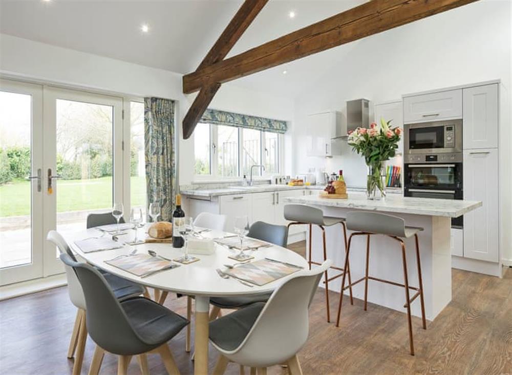 Attractive dining area with patio doors leading to garden at The Cart Barn, 
