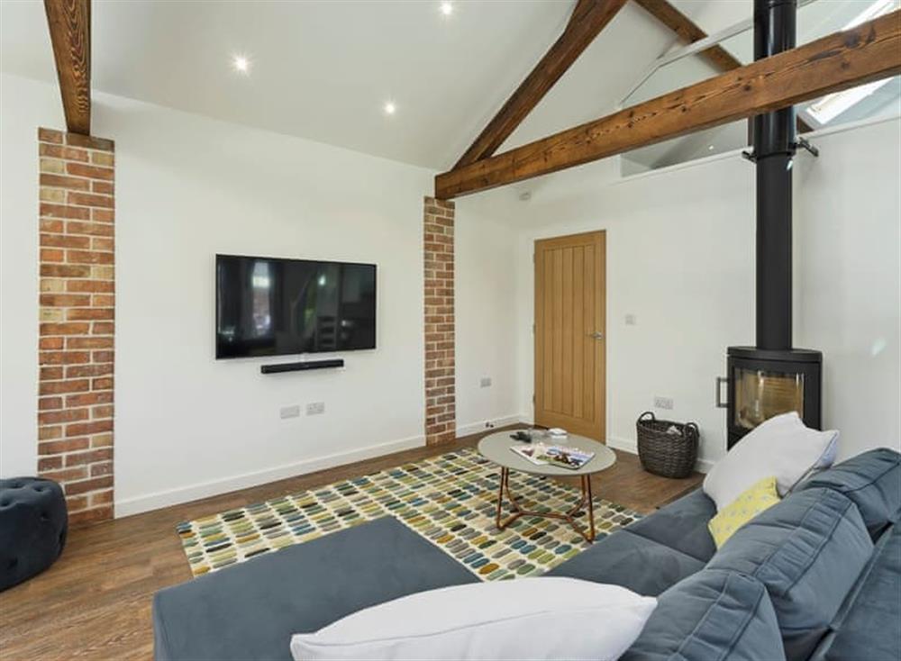 Cosy living area with wood burner at The Cart Barn, 