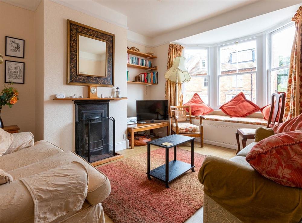 Cosy livingroom with open fire and window seating at Windward House in Salcombe, Devon