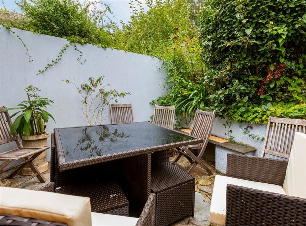 Sheltered patio with garden seating at Windward House in Salcombe, Devon
