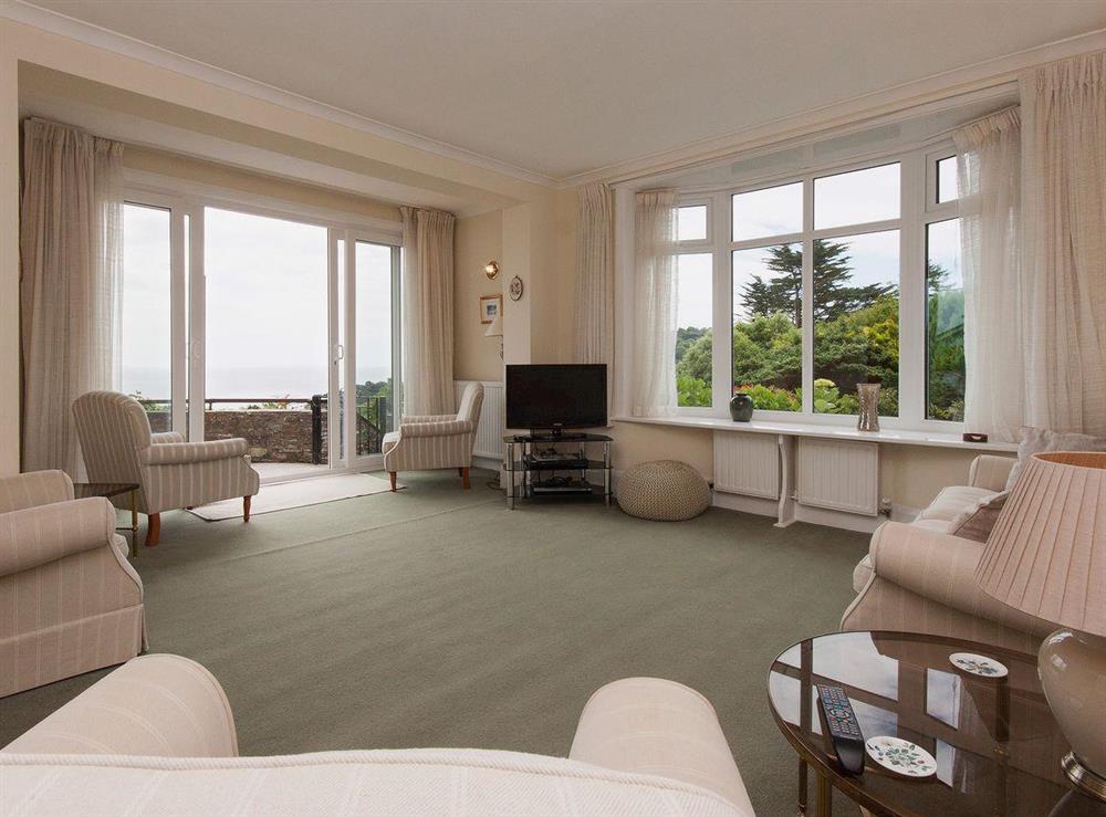 Living room with sliding glass doors to terrace at Windy Heath in Salcombe, Devon