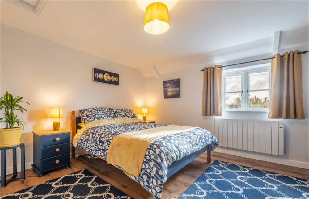 First floor: Master bedroom with king-size bed at Wishing Well Cottage, North Creake near Fakenham