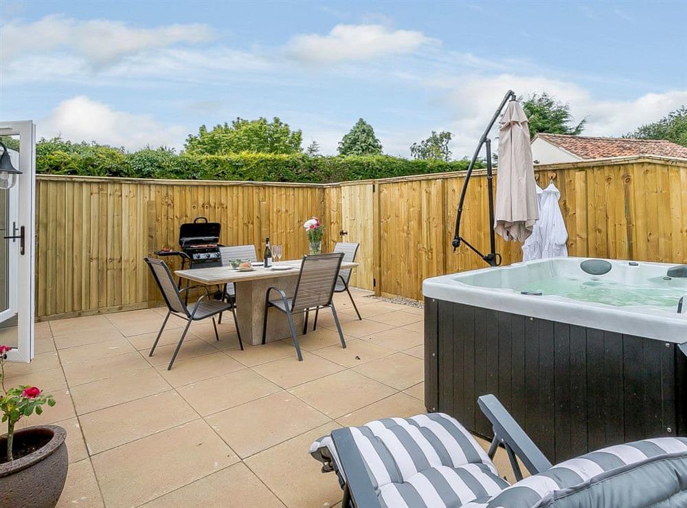 Sitting-out-area with garden furniture and private hot tub at Wits End Cottage in Roughton, near Woodhall Spa, Lincolnshire