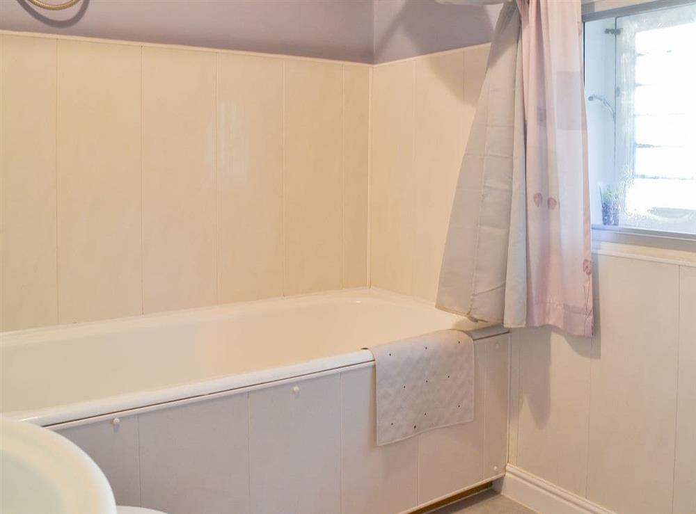 Bathroom with shower over the bath at Woodbine Cottage in Ludham, Norfolk