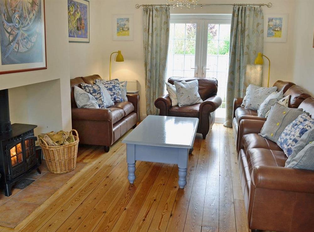 Beautifully decorated living room cosy woodburner at Woodbrook Cottage in Bothenhampton, near Bridport, Dorset