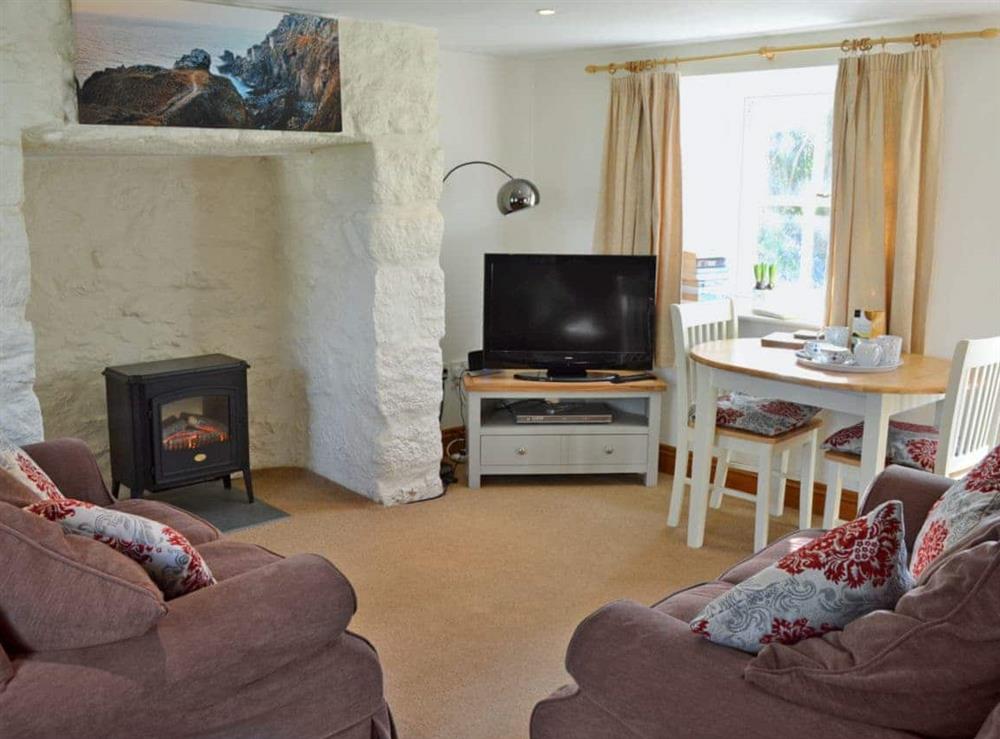 Charming living/dining room with cosy wood burner at Woodford Cottage in Rosudgeon, near Penzance, Cornwall