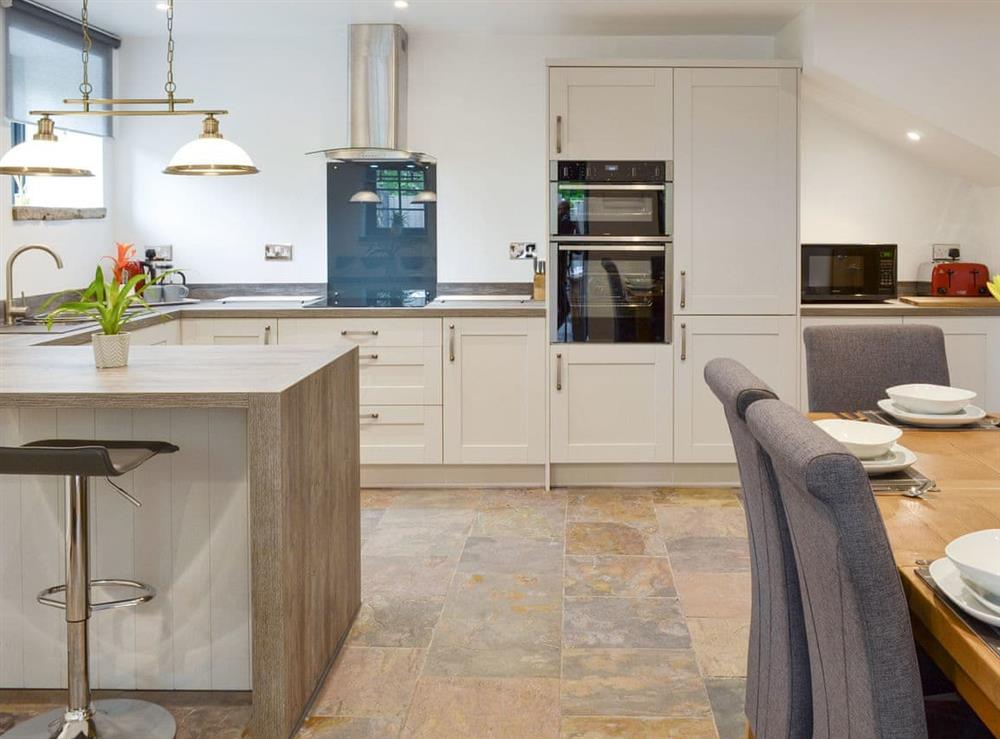 Fully appointed kitchen with breakfast bar at Woodhouse View in Frodsham, Cheshire