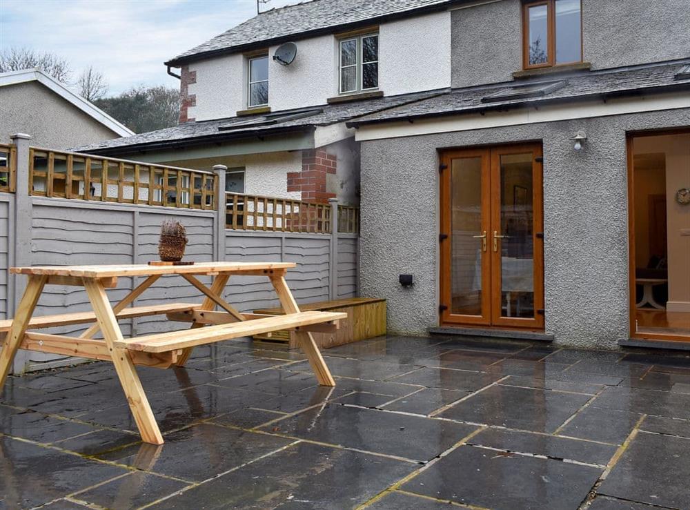 Enclosed garden with sitting-out area and garden furniture at Woodland Cottage in Backbarrow, near Ulverston, Cumbria