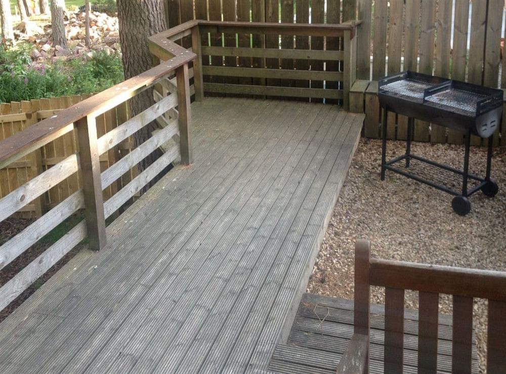 Decked area with BBQ at Woodland Lodge in Boat of Garten, near Aviemore, Inverness-Shire