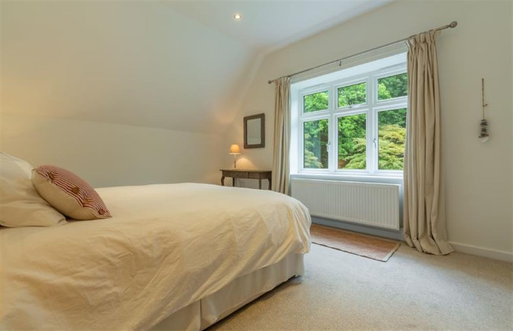 First floor: Bedroom two offers views over the woodland garden at Woodland Pytchley, West Runton near Cromer