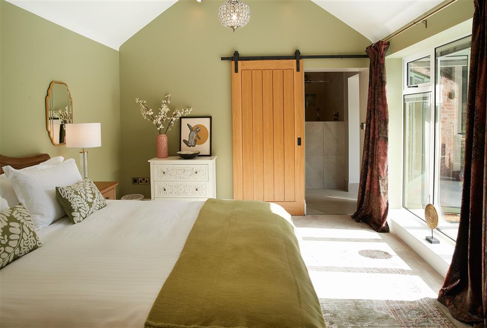 The bedroom enjoys views of the garden and the surrounding woodland at Woodland Retreat, Burton on Trent