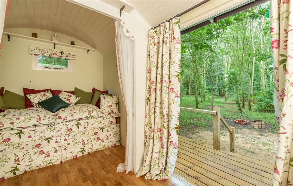 French doors lead to the wooden deck at Woodland Retreat Shepherds Hut, Brundish
