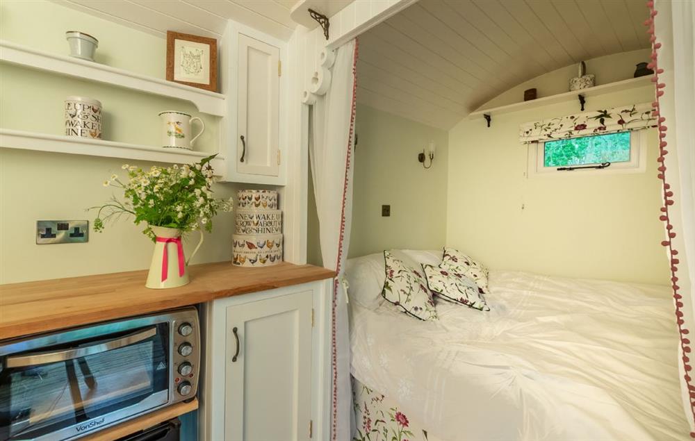 The day bed converts to a comfortable double bed at night (photo 2) at Woodland Retreat Shepherds Hut, Brundish