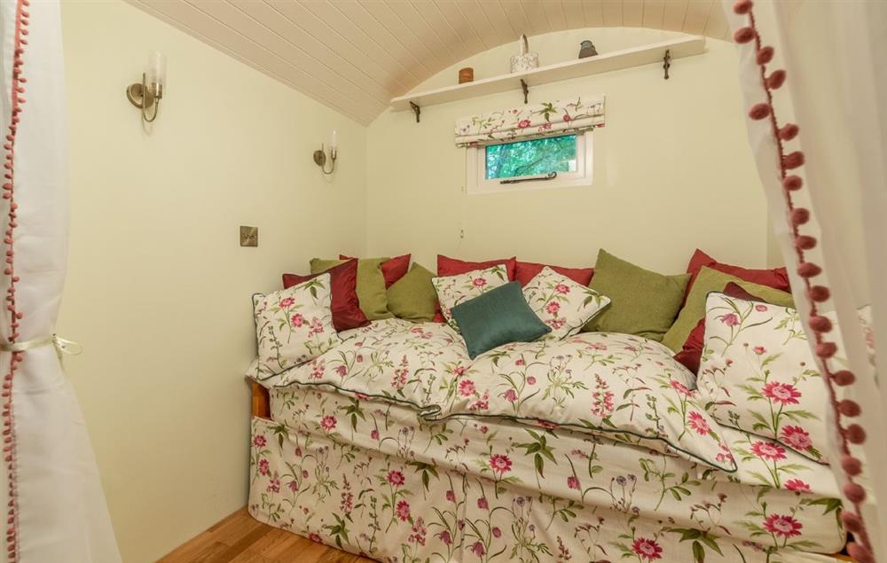 The day bed converts to a comfortable double bed at night at Woodland Retreat Shepherds Hut, Brundish