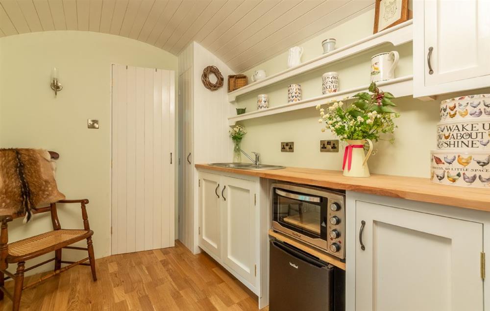 The kitchen, complete with fridge, electric combination oven and sink at Woodland Retreat Shepherds Hut, Brundish