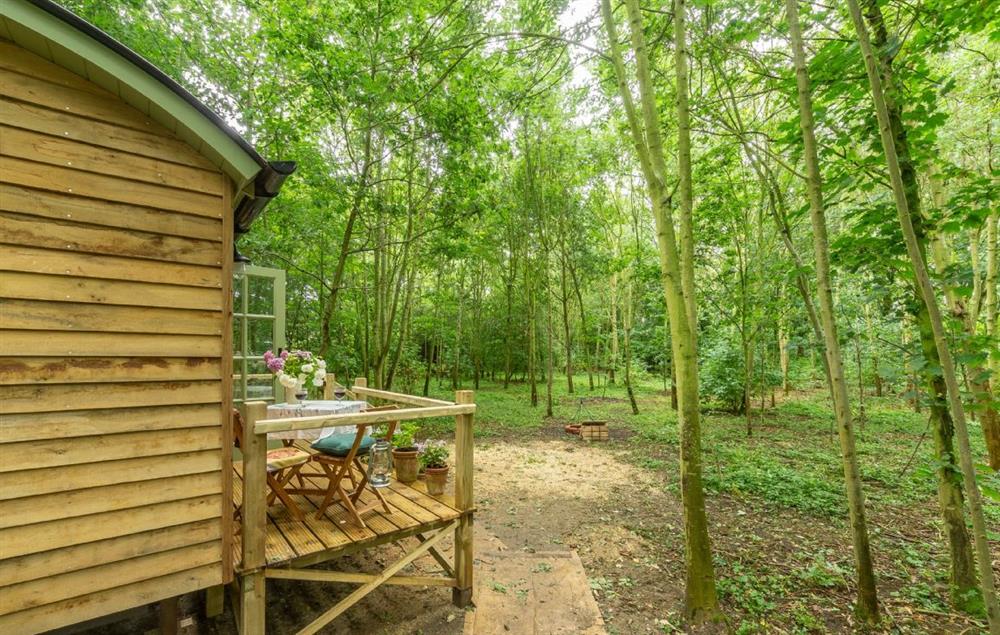The wooden deck with garden table and chairs  (photo 2) at Woodland Retreat Shepherds Hut, Brundish