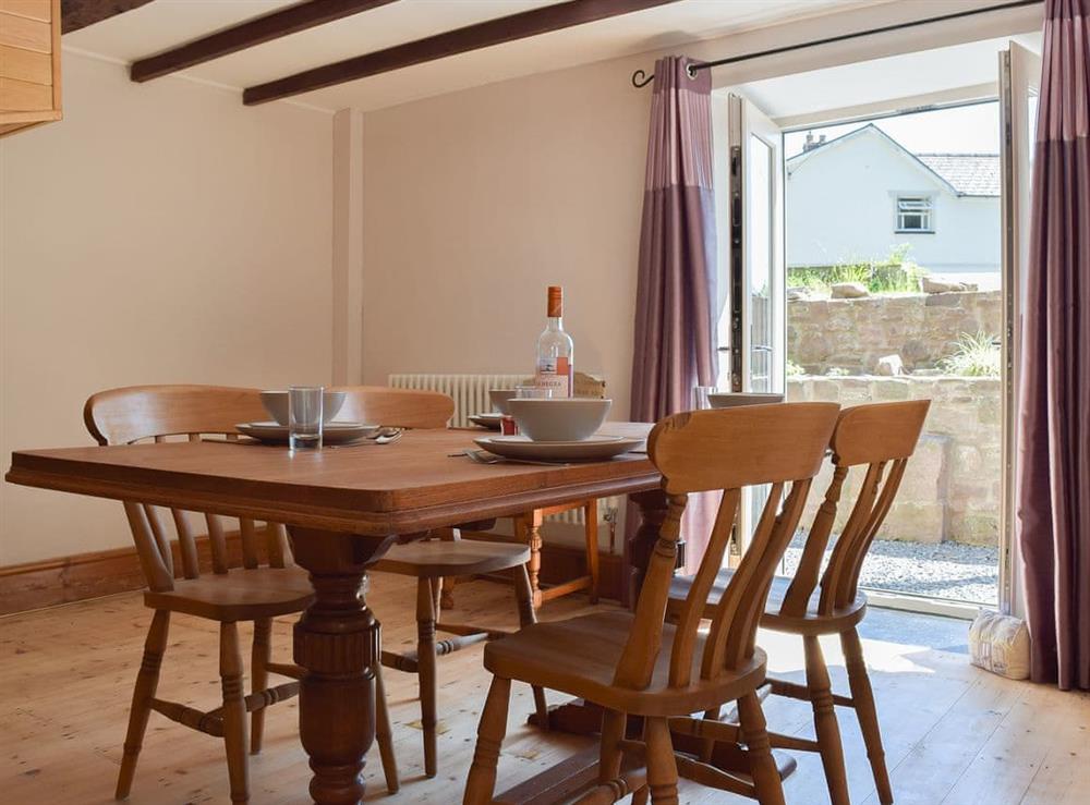 Beamed dining area with doors to the courtyard at Woodlands in Laugharne, near Pendine, Carmarthenshire, Dyfed