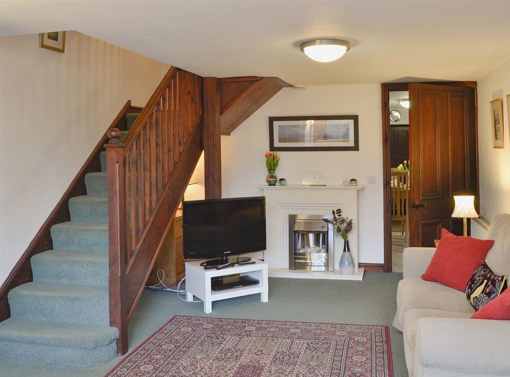 Airy living room with open staircase to first floor at Woodpecker Cottage in Wigton, Cumbria