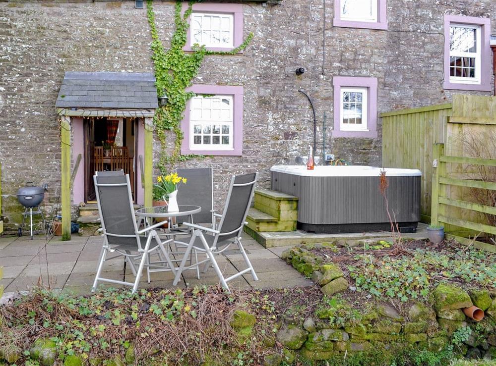 Spacious patio with hot tub and sittng out area at Woodpecker Cottage in Wigton, Cumbria