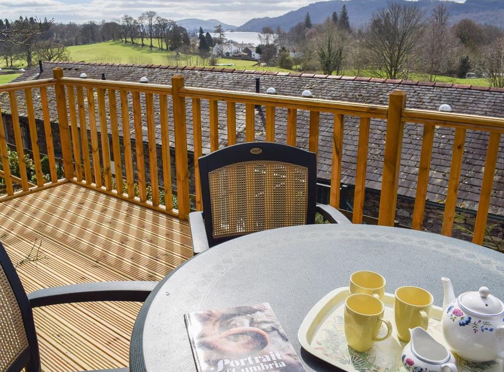 Decked area with table and chairs at Woodside Cottage in Ecclerigg, near Ambleside, Cumbria
