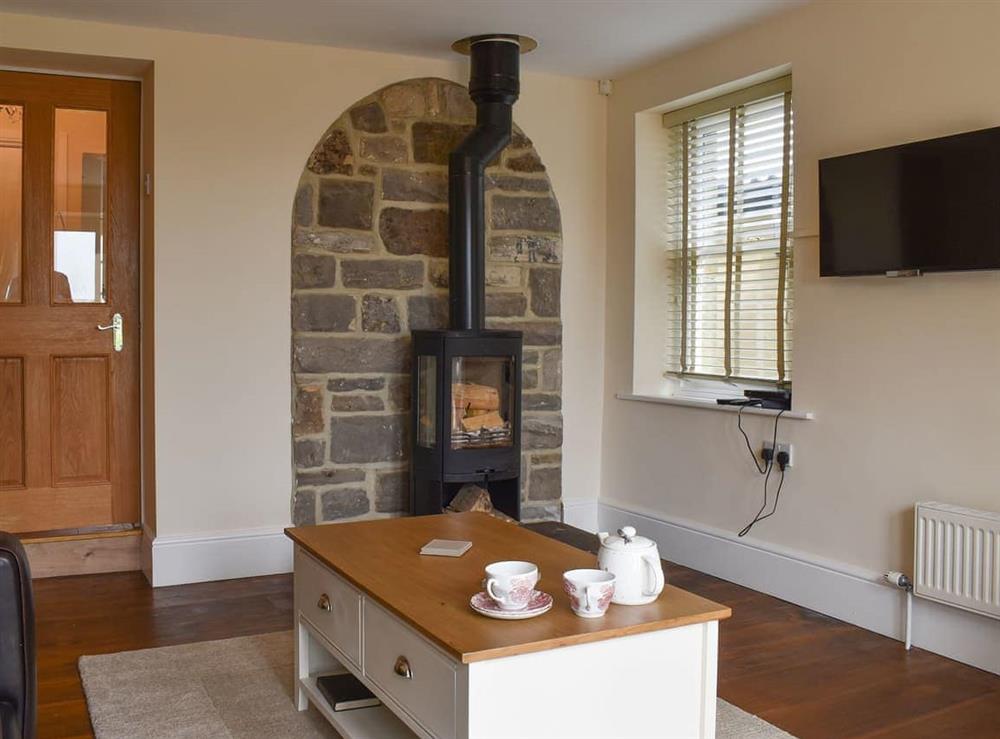 Living room/dining room featuring a stone fireplace and log burner at Woodside Cottage in Near Easington, Cleveland