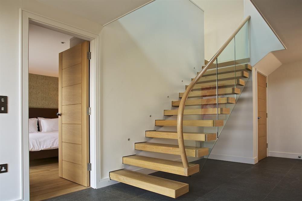 An elegant oak staircase leads to the living accommodation