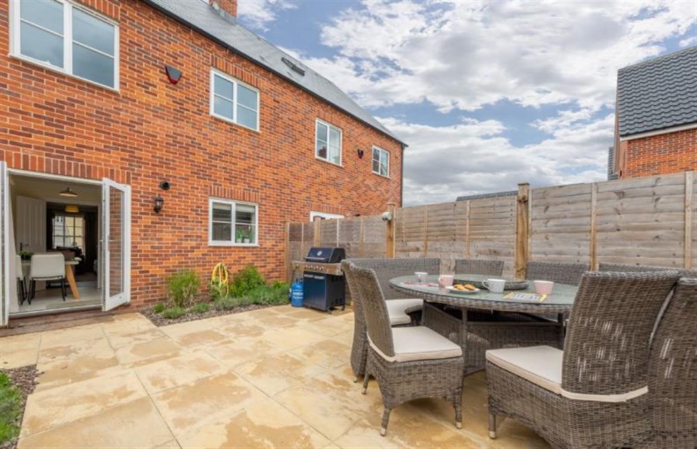 Enclosed, south facing courtyard garden with furniture with seating for six guests and gas barbecue at Wye Cottage, Holt
