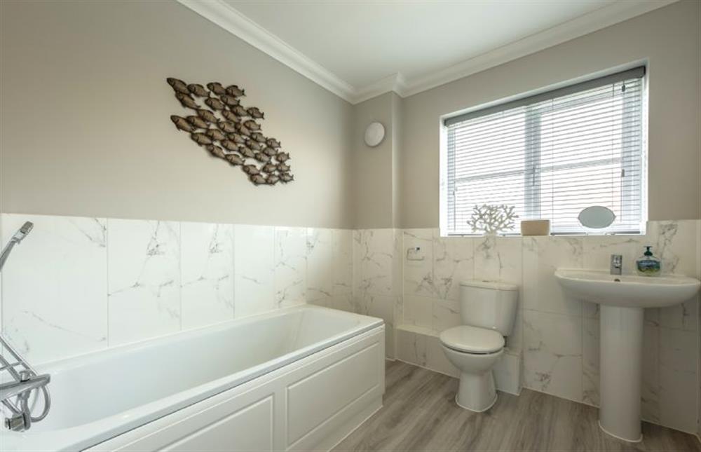 First floor: Family bathroom with bath and hand-held shower, wash basin and WC at Wye Cottage, Holt
