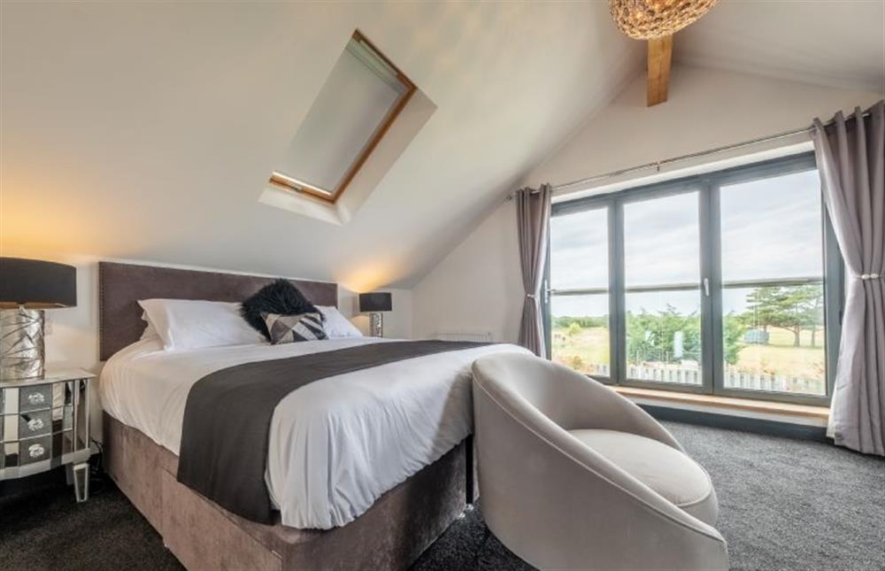 Bedroom one with a 6’ super-king size bed and en-suite shower room at Wynholme, Holme-next-the-Sea