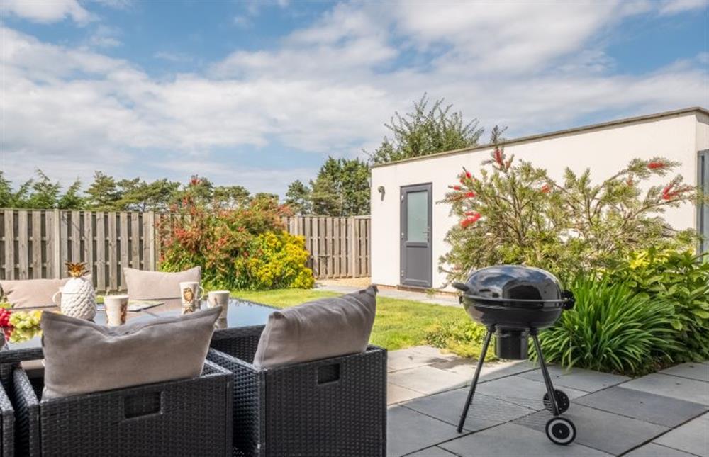 Patio area with gas barbecue and seating at Wynholme, Holme-next-the-Sea